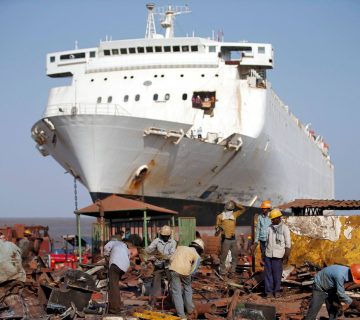 FILE PHOTO: Workers sort out scrap metal of a decommissioned ship at the Alang shipyard